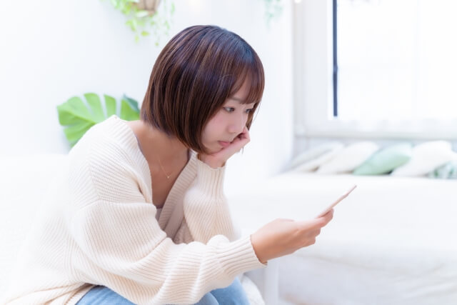 スマホをいじる女性