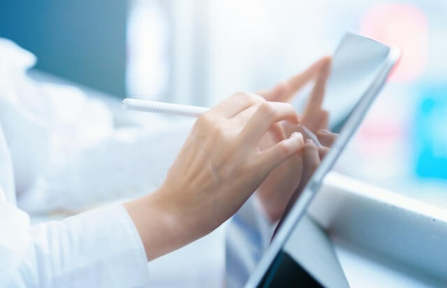 タブレットに何か書き込んでいる女性