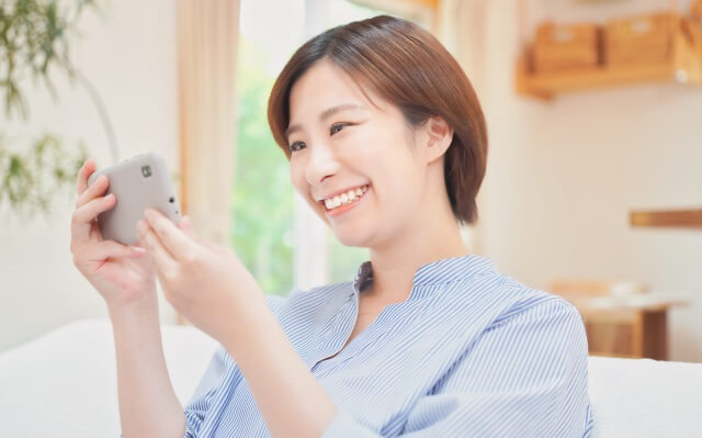 スマホを笑顔でみている女性