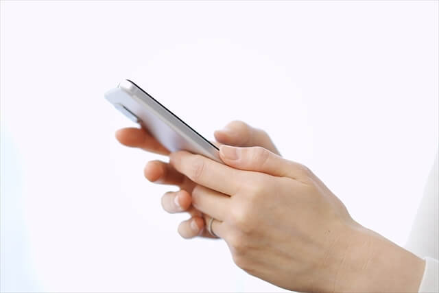 スマホを持つ女性の手