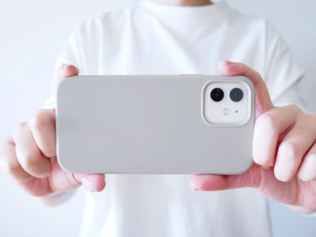 スマホでカメラをとる男性