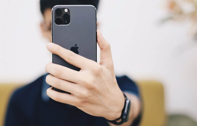 iphone11でカメラを撮ろうとしている男性