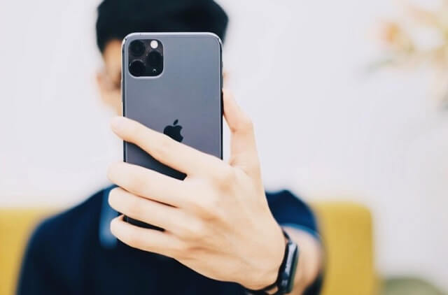iphoneでカメラをとる男性