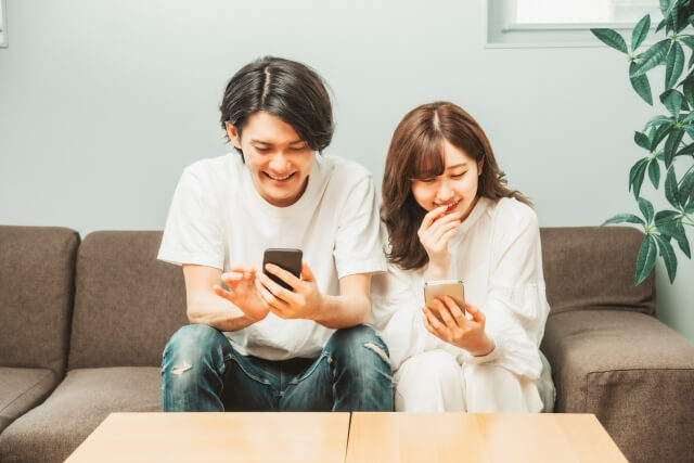 男女がスマホを見て笑っている様子