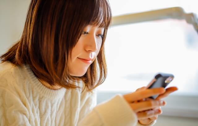 スマホをいじる女性