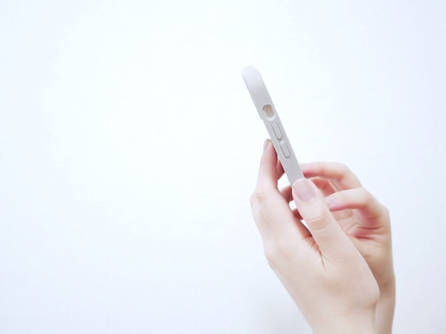 スマホをタップする女性の手