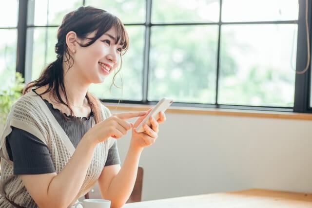 カフェでスマホをいじる女性