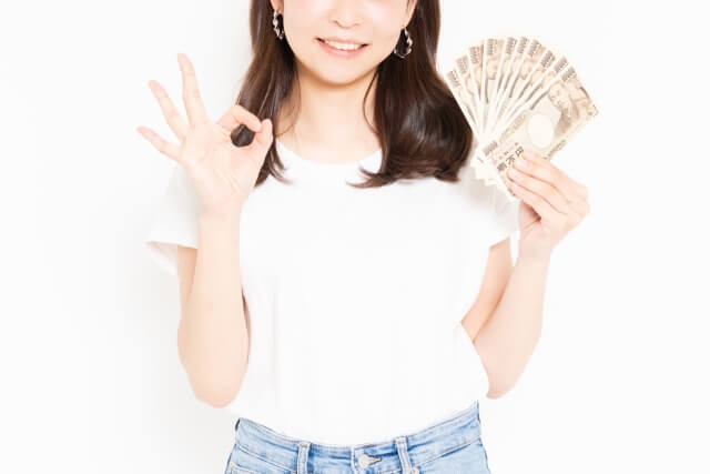 お金を持ちokサインする女性