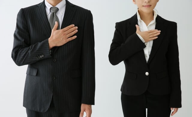 男女のビジネスマンが胸に手をあてている