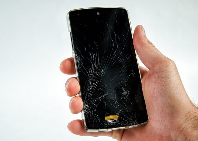 画面にひびが入ったスマホを持つ手