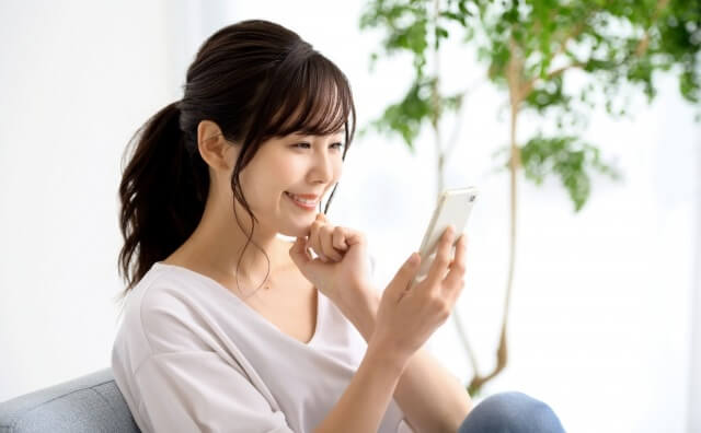 スマホを見てほほ笑む女性
