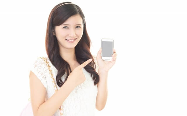 女性がスマホを指さしている