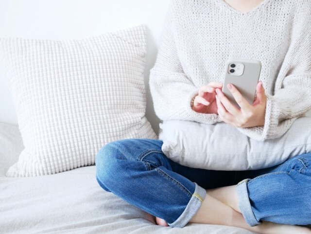 座ってスマホを扱う女性