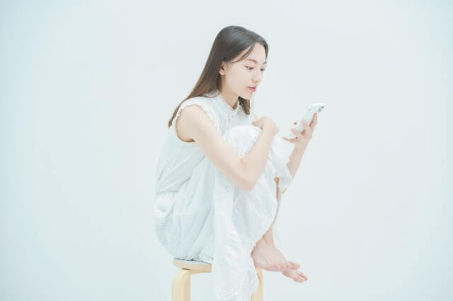 椅子に座りスマホをいじる女性