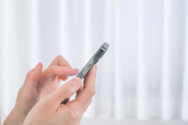 スマホをタップする女性の手