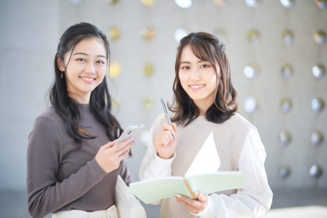 スマホをもった女性二人がこちらを見ている様子