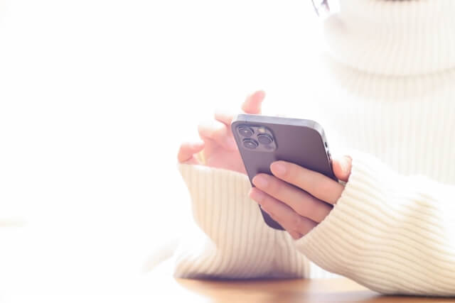 スマホをいじる女性の手