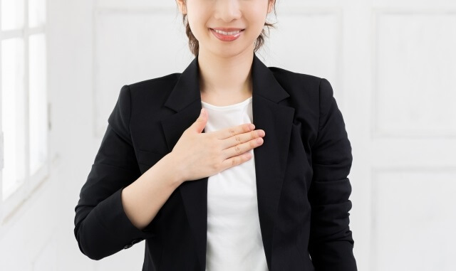 胸に手をあてる女性のビジネスマン