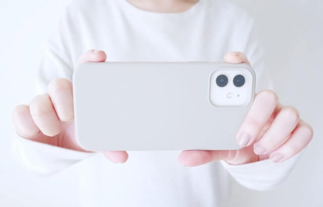 iphoneでカメラをとる男性