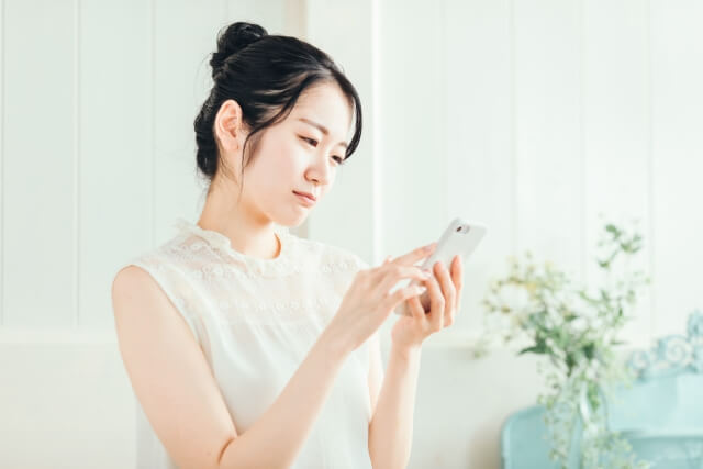 スマホを見て困っている女性