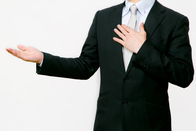 どうぞという身振りをしている男性のビジネスマン