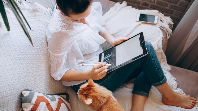ipadを使う女性と猫