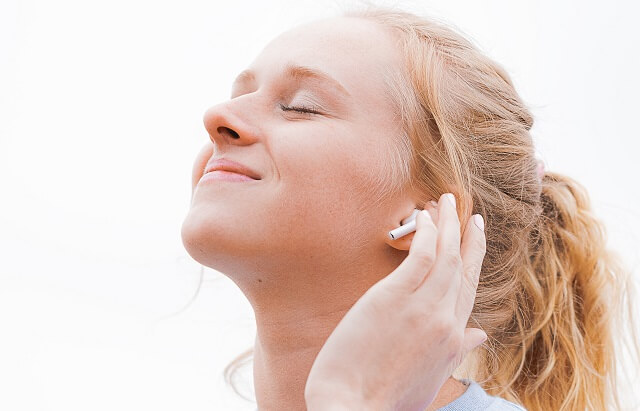 airpodsで音楽を聴く女性