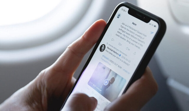iphoneでtwitterをしている男性
