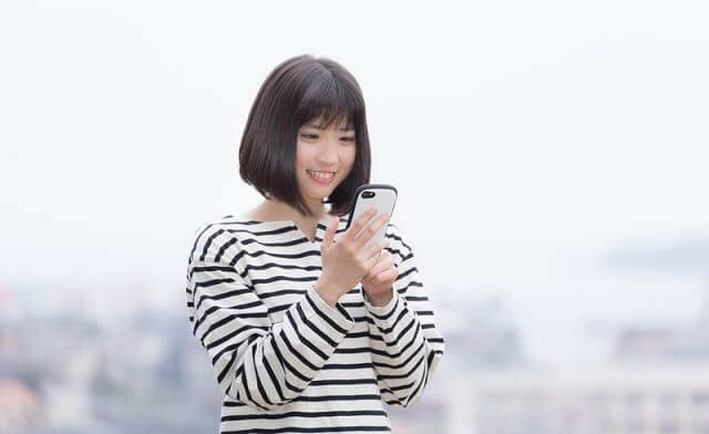 スマホを見て笑う女性