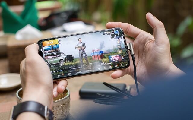 スマホでゲームをする男性
